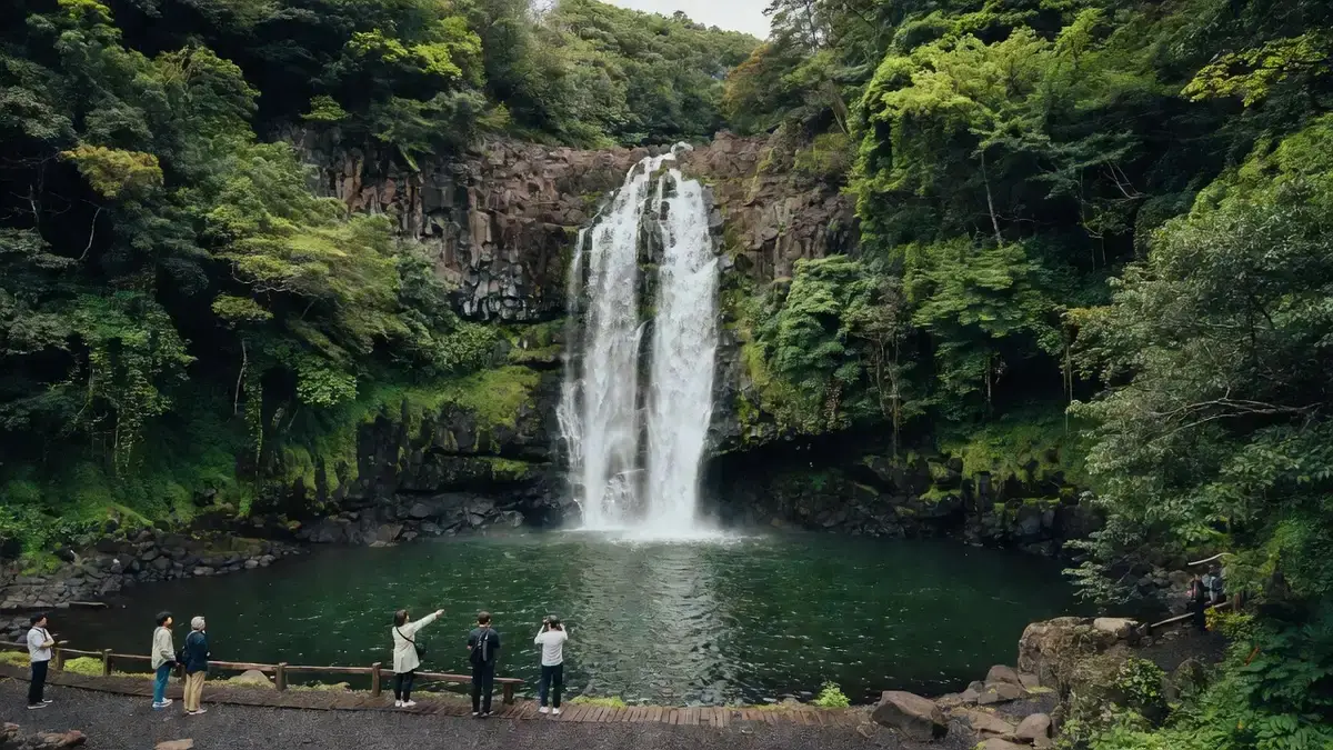 Cheonjiyeon waterfall dropping into a forest pool near Seogwipo on a tour of Jeju Island Korea, South Korea